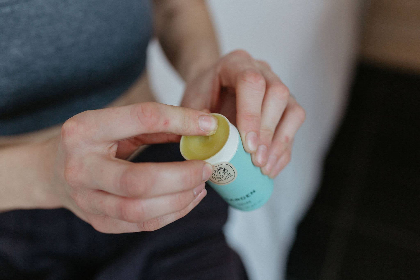 Hand applying nourishing garden salve to care for hardworking hands, perfect for gardeners and farmers.