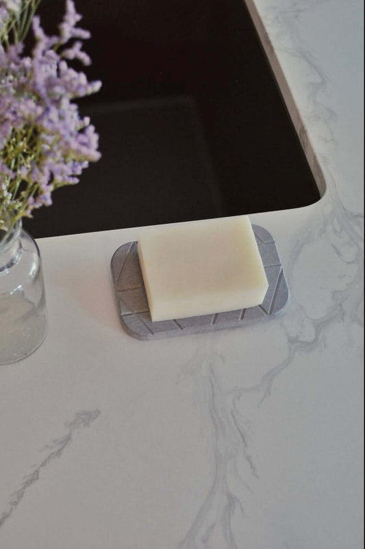diatomite soap dish in gray with soap placed on top next to a sink