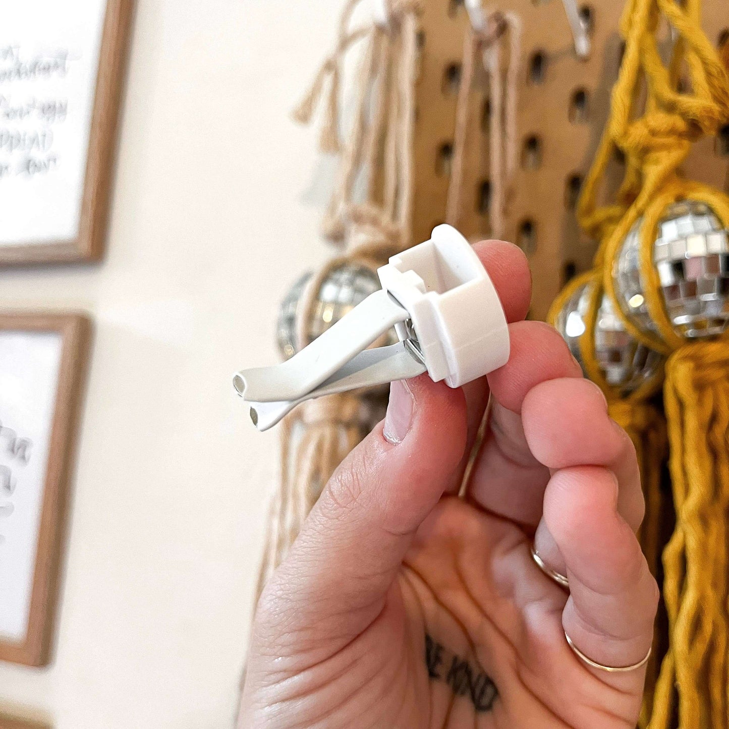 Hand holding a white car vent clip diffuser for essential oils, designed for use in cars as a freshening accessory.