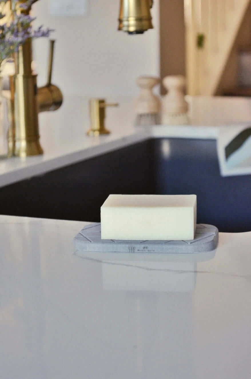 diatomite soap dish with soap on top with sink and faucet in background