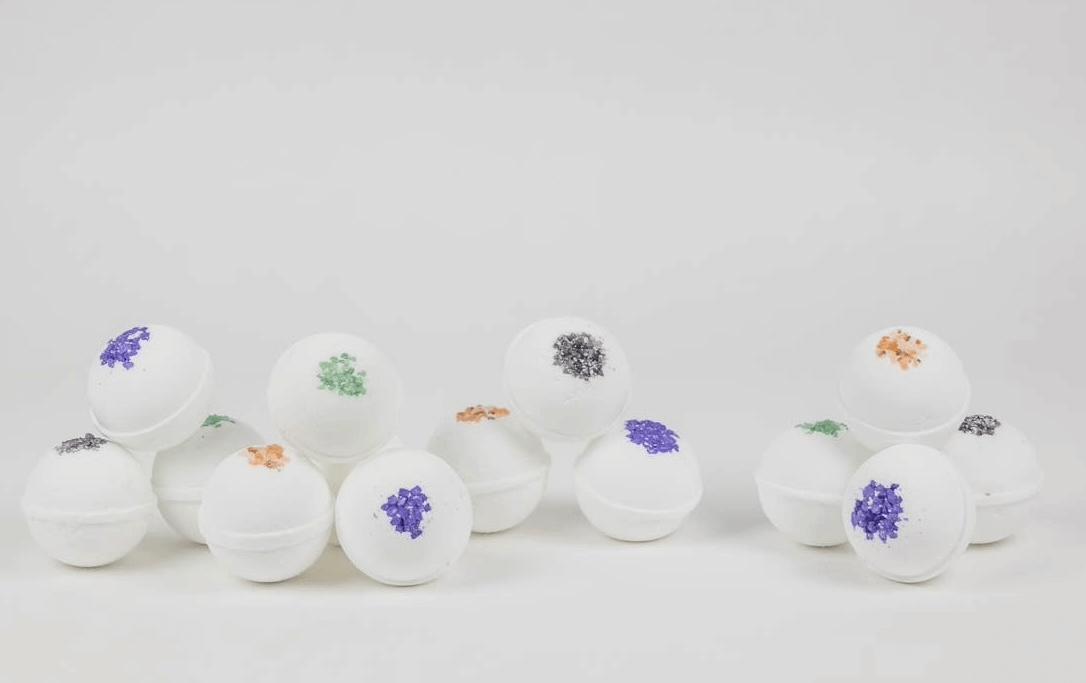 Handmade natural bath bombs with colorful herbal accents, infused with peppermint essential oils, chemical-free.