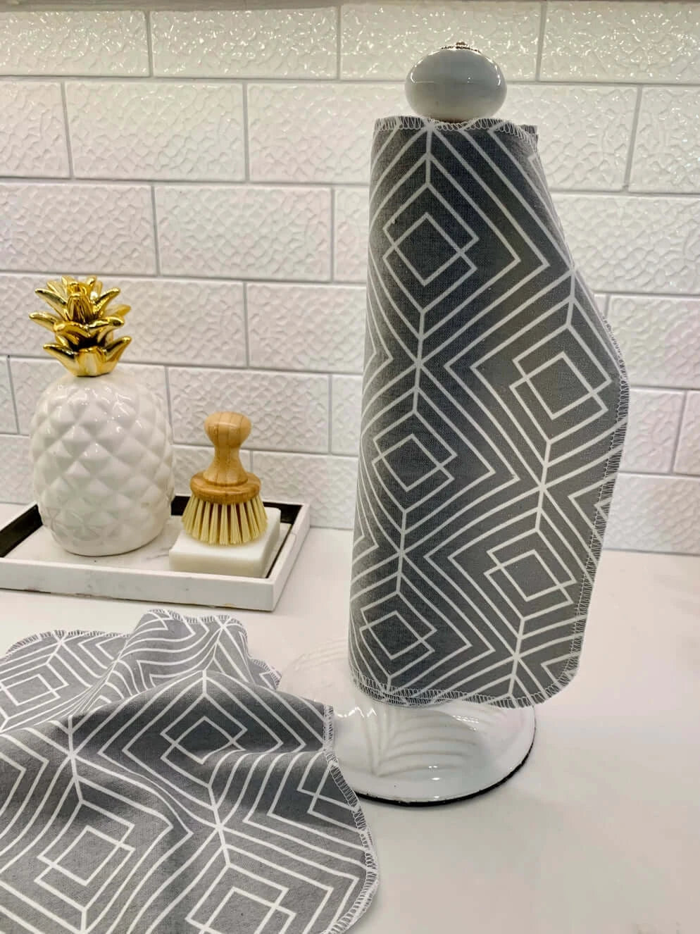 nonpaper towels wrapped around a paper towel dispenser with 1 laid flat on the counter