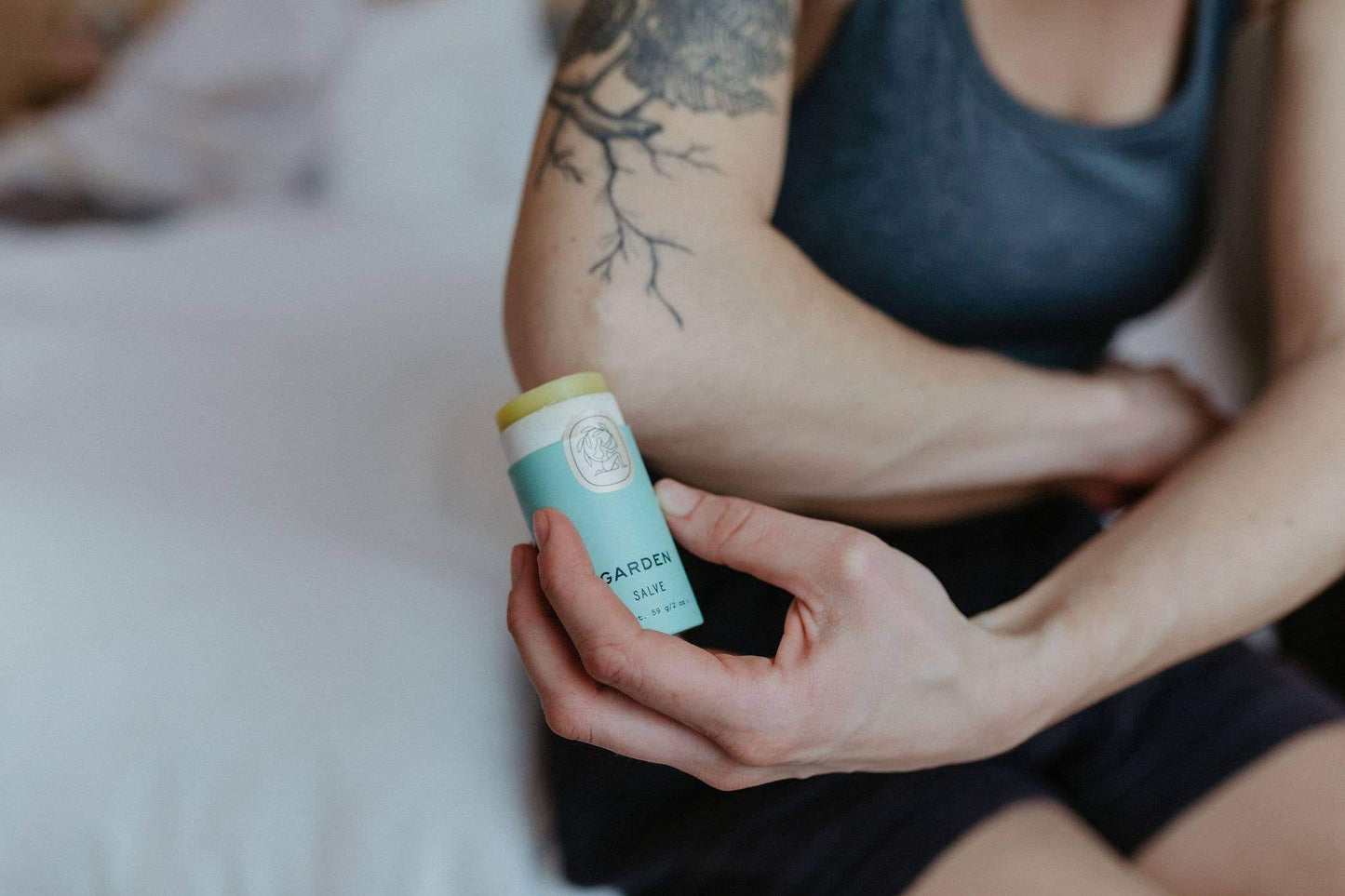 Hand holding a handcrafted Garden salve for nurturing and soothing hardworking hands.