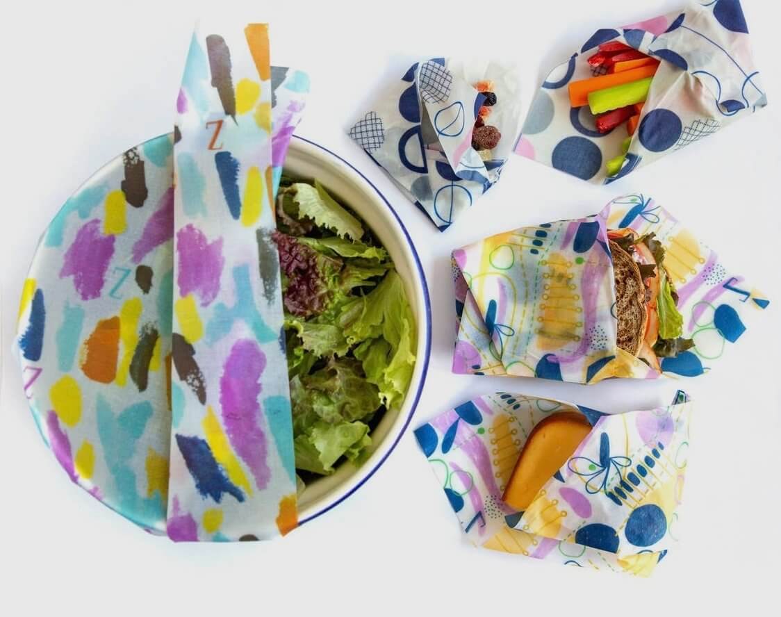 zwraps reusable food wraps wrapped around a bowl to keep lettuce fresh and made into storage bags to keep sandwiches and veggies good