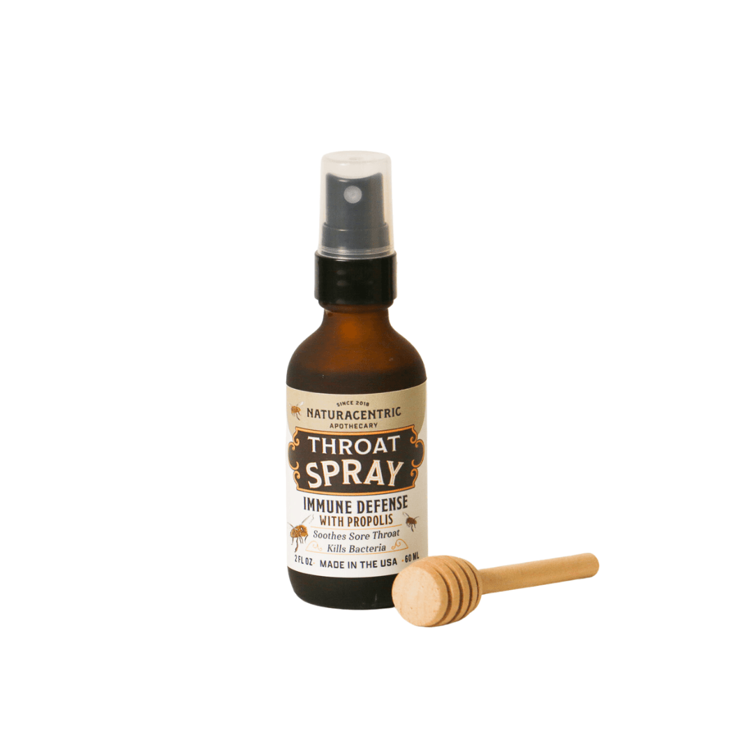 Immune Defense Throat Spray with Propolis & Honey in a bottle with a honey dipper on the side.