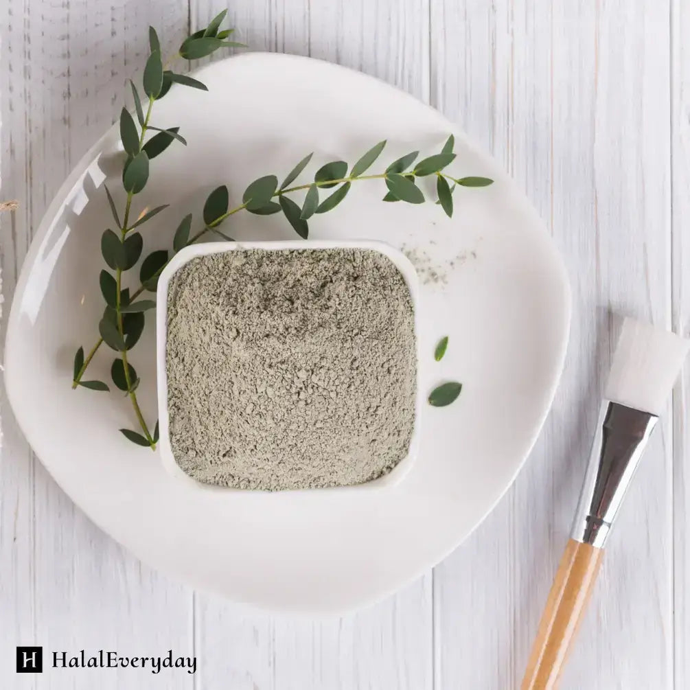 Bentonite clay in a square dish with green leaves, perfect for deep pore cleansing and skincare treatments.