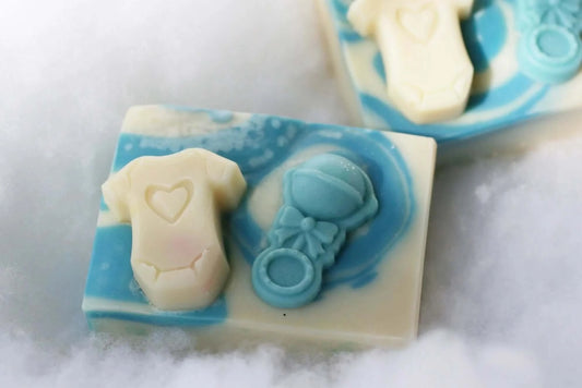 organic handmade soap in blue and white with onesie and rattle