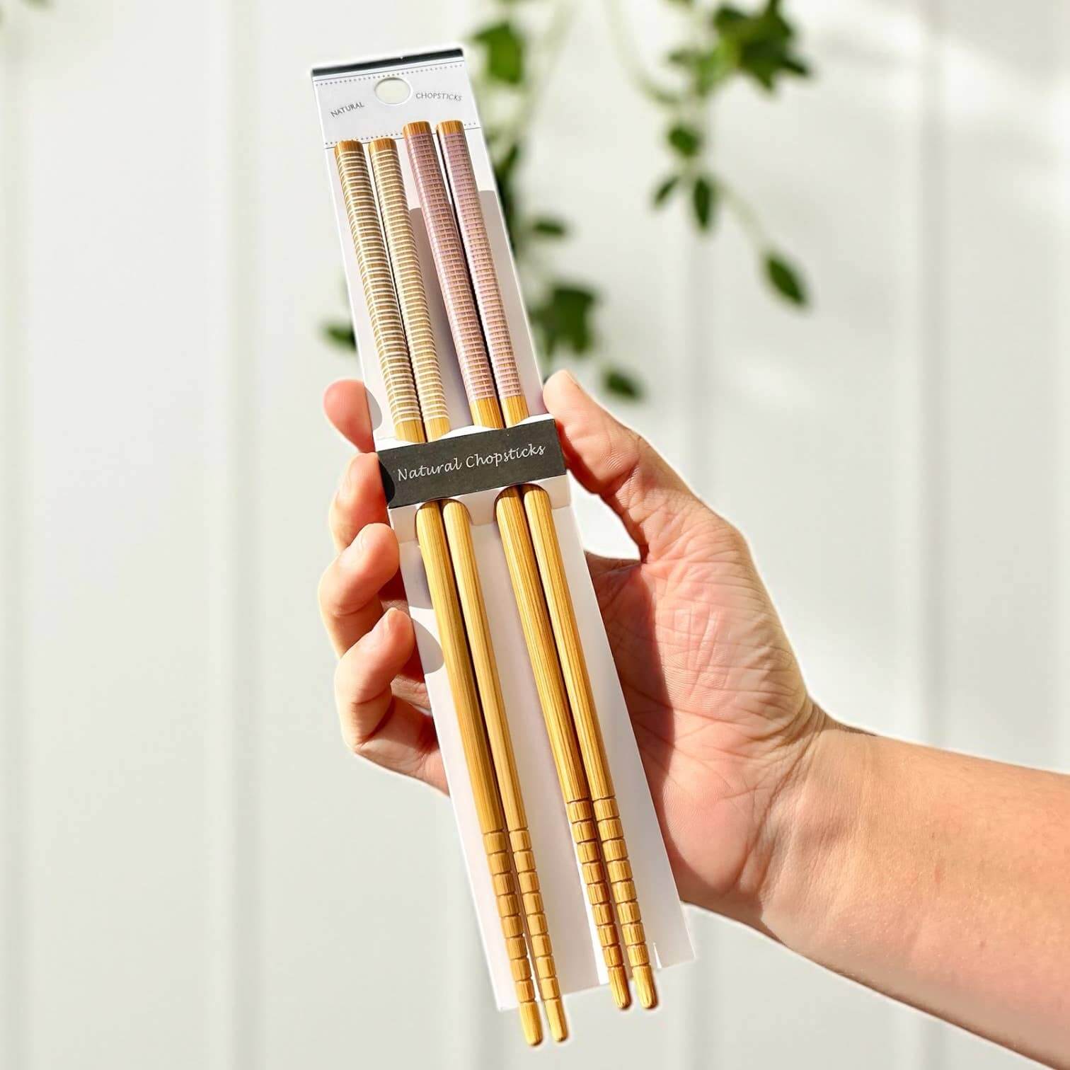 Bamboo Chopsticks Set | Holiday Stocking Stuffer: Black & Black in hand, showcasing sustainable dining utensils.