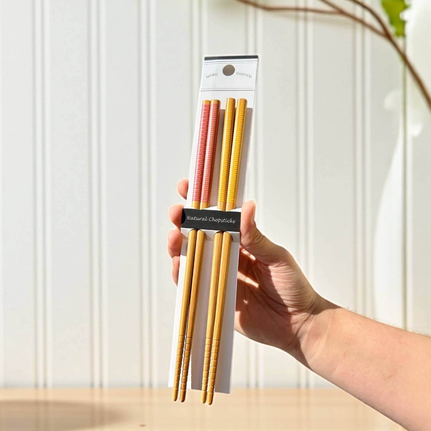 Bamboo Chopsticks Set | Holiday Stocking Stuffer: Black & Black held in hand, showcasing sustainable and reusable utensils.