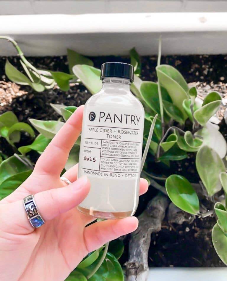 4oz Clean Skin Toner bottle with apple cider and rosewater, surrounded by green plants, showcasing non-toxic skincare.