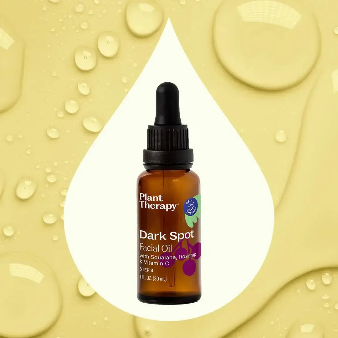 Dark Spot Facial Oil 30ml in a dropper bottle with a water droplet background, showcasing its antioxidant-rich formula.