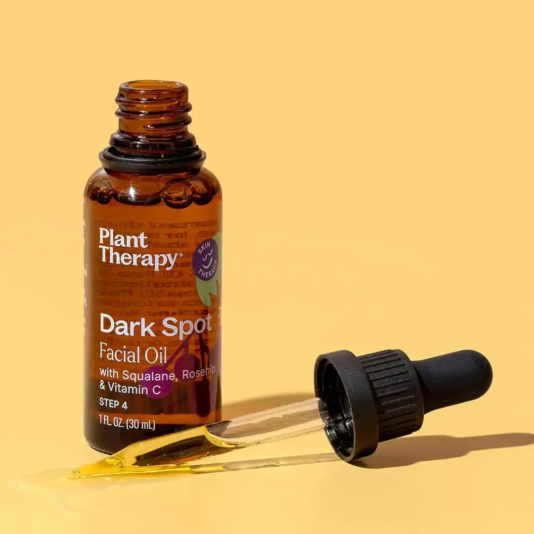 Dark Spot Facial Oil 30ml bottle with dropper on a yellow background.