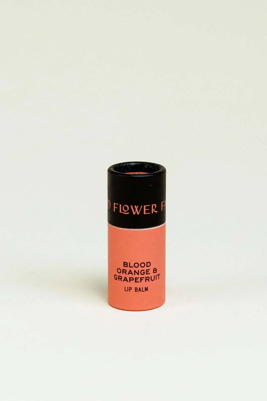 Organic lip balm in a biodegradable container in blood orange and grapefruit.
