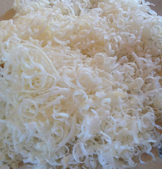 Shredded white soap flakes for easy mixing and dilution in liquid soap preparation.