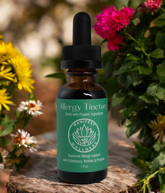 Organic Allergy Blend Tincture in a glass dropper bottle surrounded by flowers, designed for seasonal allergy relief.