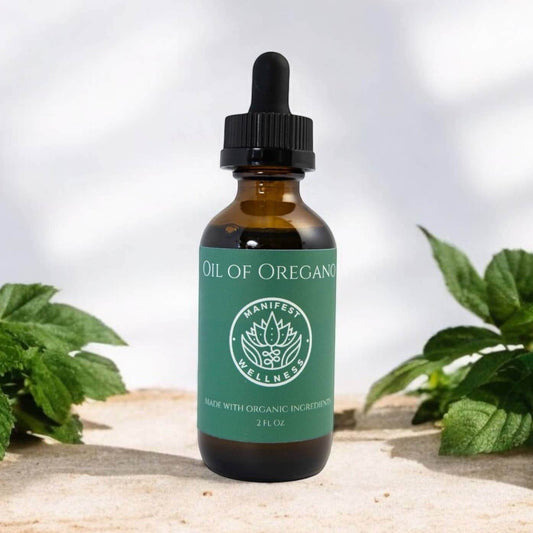 Bottle of Oil of Oregano with a dropper on a wooden surface with green leaves in the background