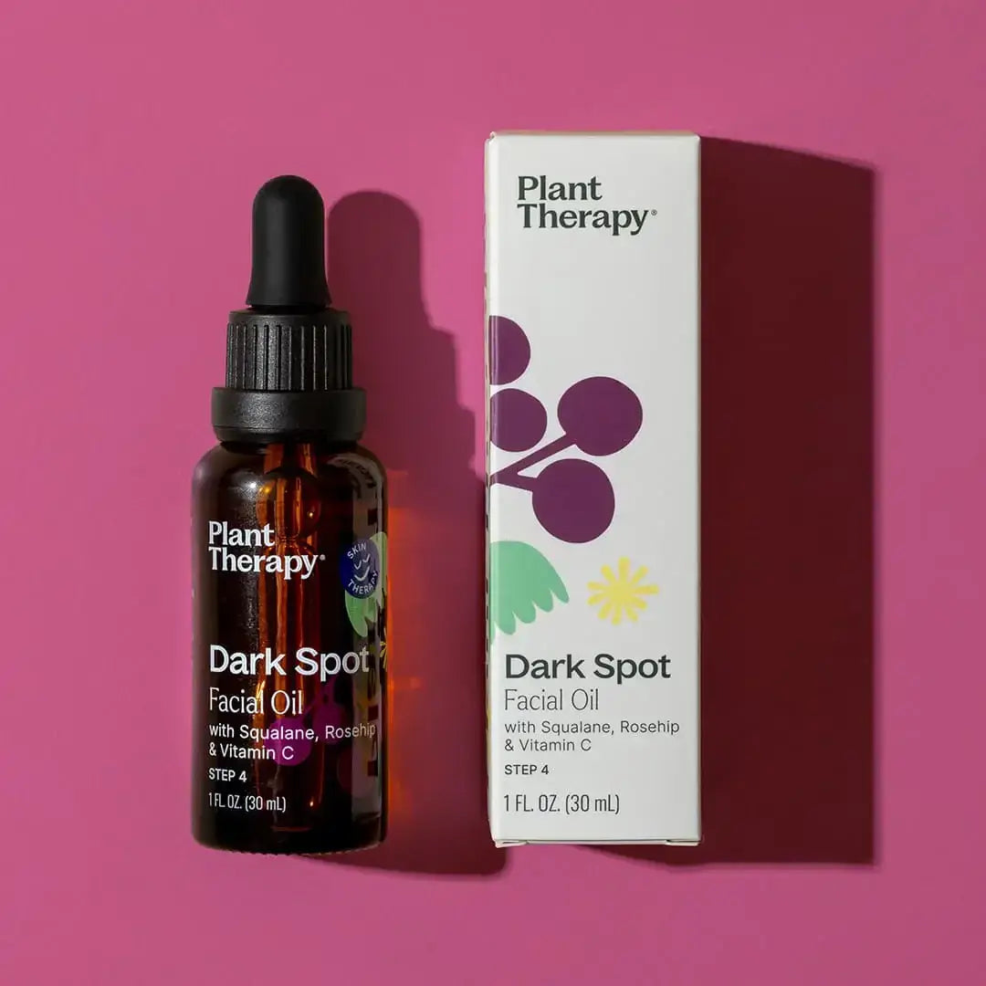 Dark Spot Facial Oil 30ml bottle and packaging on pink background, highlighting skincare benefits.