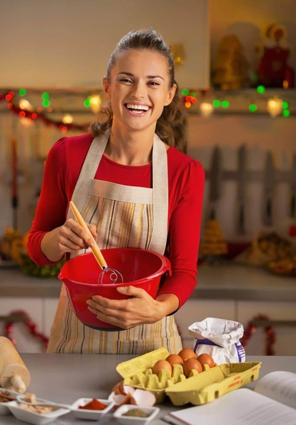 LHU - Premium Original Danish Dutch Whisk in use by a smiling woman in a festive kitchen, mixing ingredients in a red bowl.