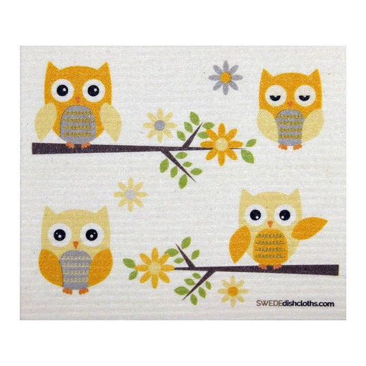 White swedish dishcloth with four yellow owls. Two sitting on branches with yellow flowers and green leaves.