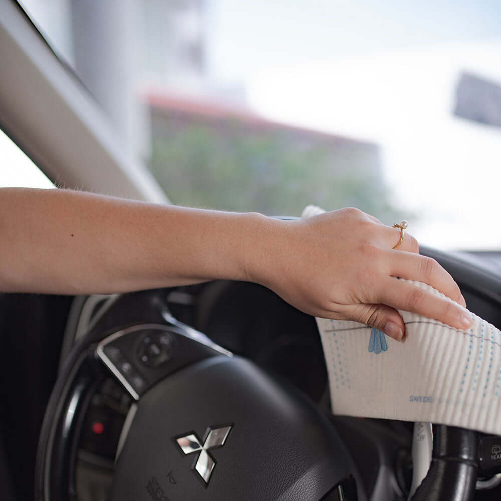 swedish dishcloth being used to clean a steering wheel 