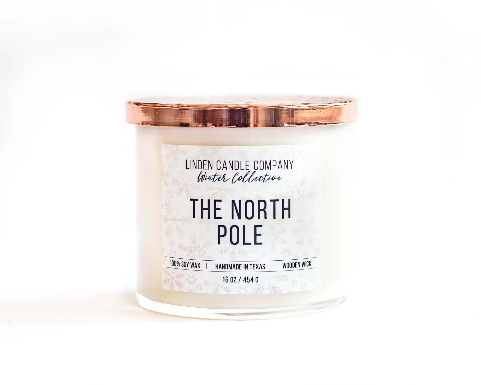 The North Pole 16oz Seasonal Winter Soy Candle with hammered copper lid and wooden wick.