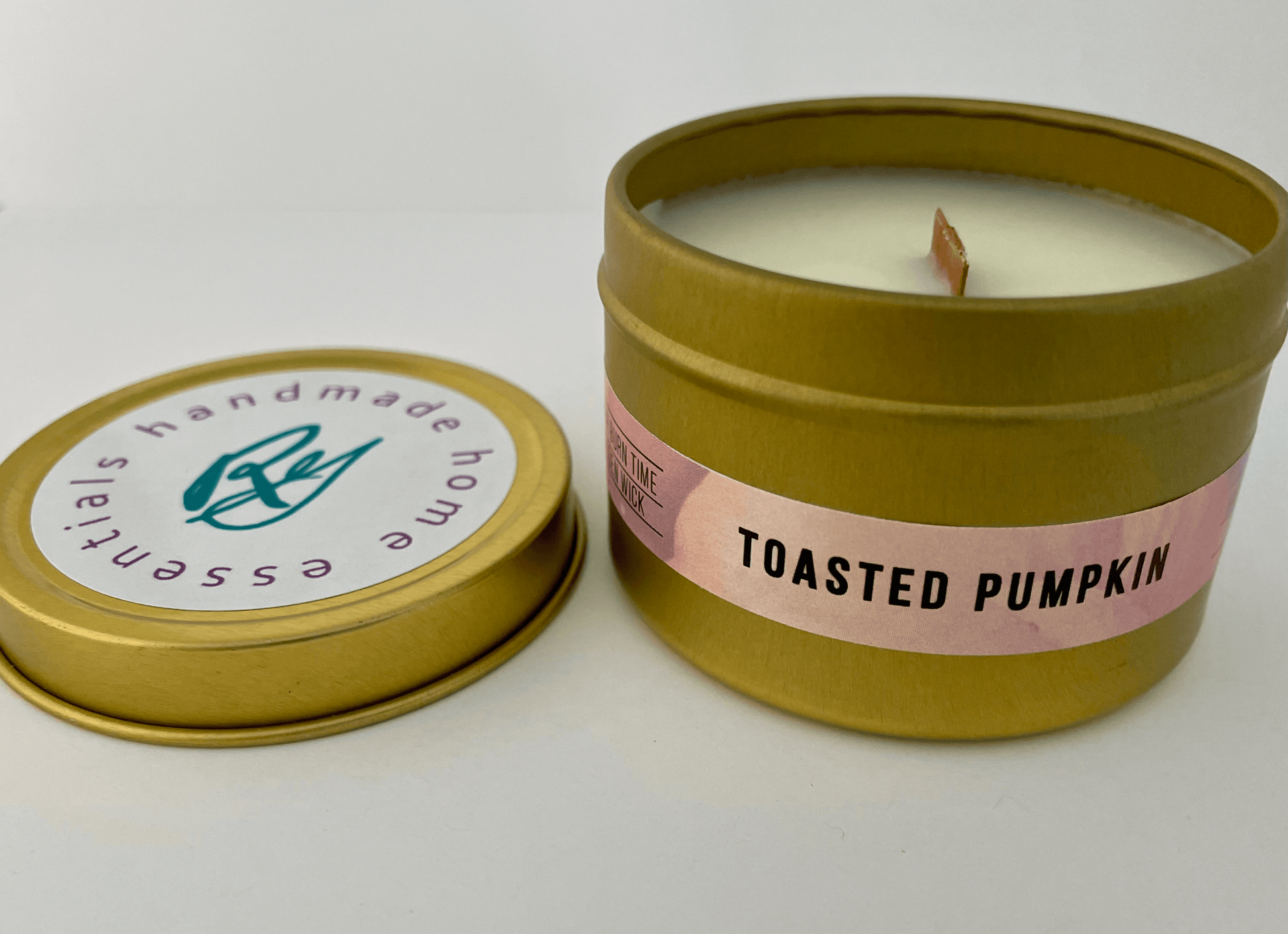 Toasted pumpkin travel candle with the lid off and sitting next to it,