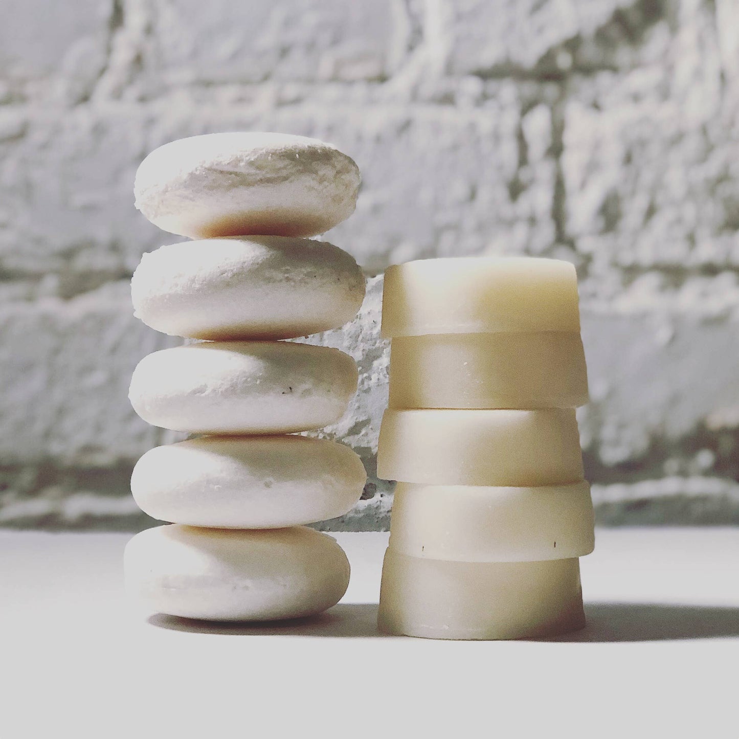 5 shampoo bars stacked on top of eachother next to 5 conditioner bars