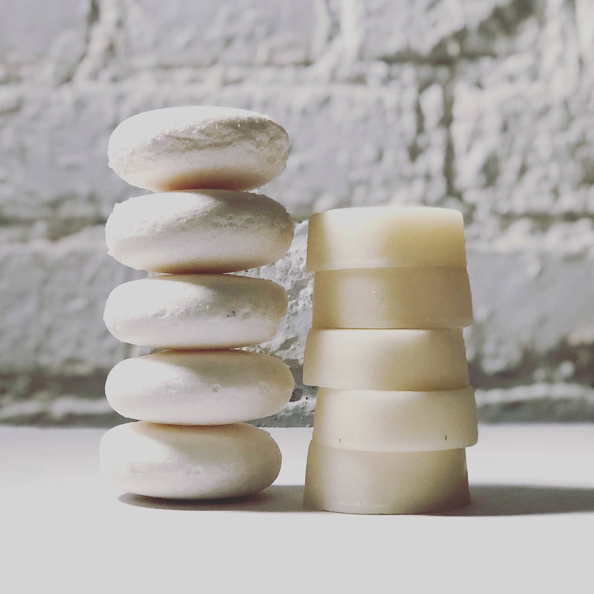 5 shampoo bars stacked on top of eachother next to 5 conditioner bars